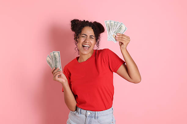 istock Happy woman with dollar banknotes on pink background 2210346456