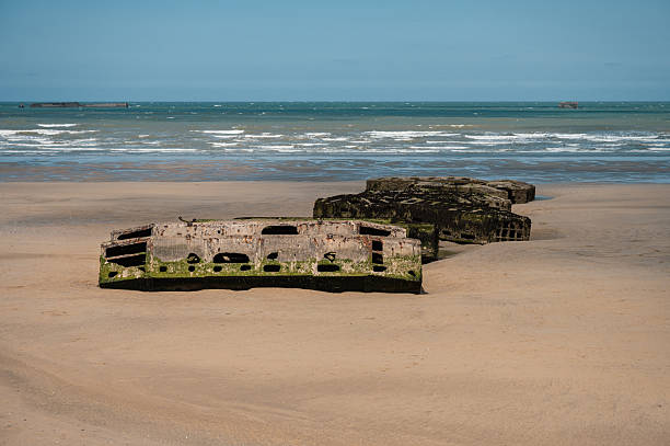 Visible remains of the Mulberry Harbour platforms on the beach of Arromanches-les-Bains, France. These massive concrete structures were used during the D-Day landings in World War II.
