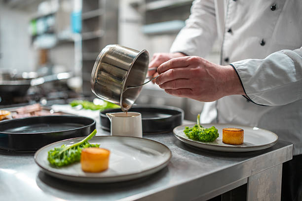 istock Chef Plating Elegant Cuisine in Professional Kitchen with Sophisticated Lighting and Precision 2210347672