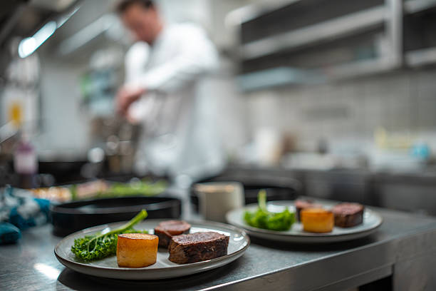 istock Elegant Plated Dishes With Seared Meat And Vegetables On Restaurant Kitchen Counter 2210347677