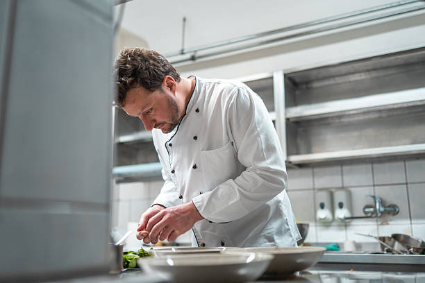 istock Focused Chef Plating Gourmet Dish in Professional Kitchen with Modern Stainless Steel Background 2210347727