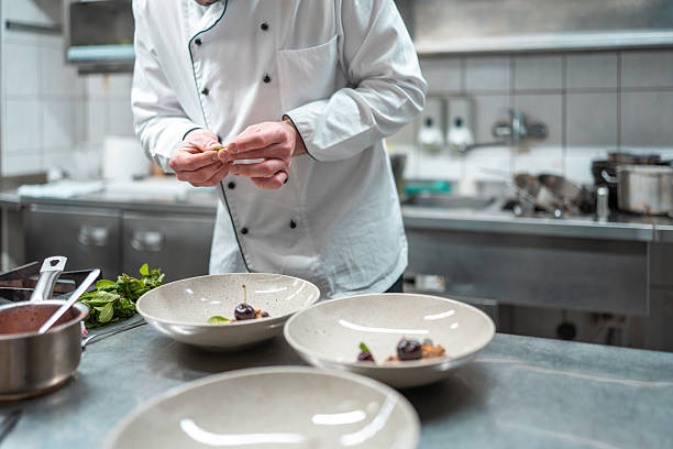 istock Chef Plating Gourmet Dish in Professional Kitchen with Fresh Ingredients 2210347732