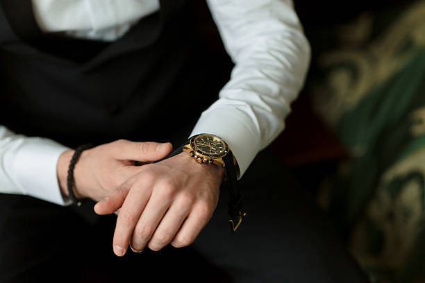 istock A man is wearing a black suit and a gold watch 2210351572
