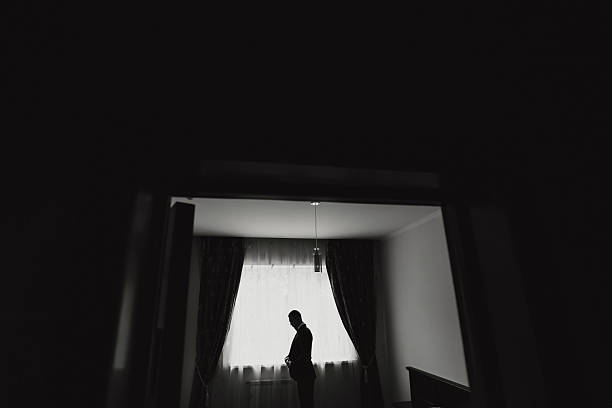 istock A man is standing in a room with a window 2210351582