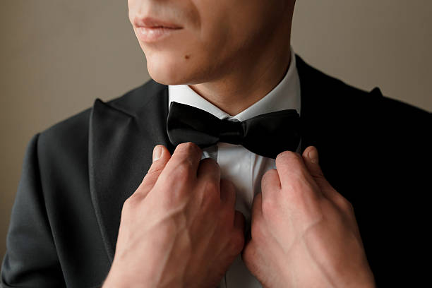 istock A man is getting ready to wear a black bow tie 2210351590