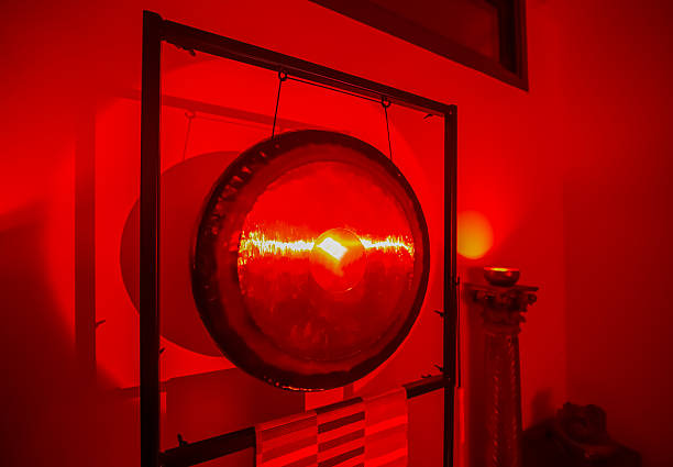 istock Large Gong in Red Ambient Lighting with Reflective Surface and Decorative Elements for Meditation 2210351733