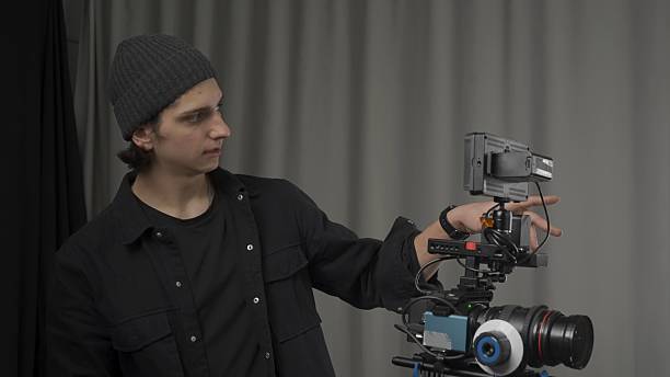 istock The operator adjusts a professional video camera standing on a tripod close up. Behind the scenes of filming video production. 2210358229