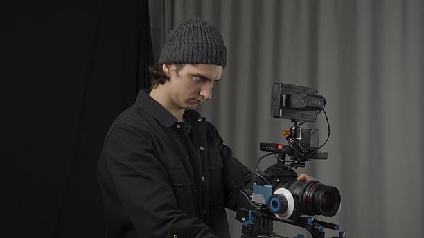istock The operator adjusts a professional video camera standing on a tripod close up. Behind the scenes of filming video production. 2210358259