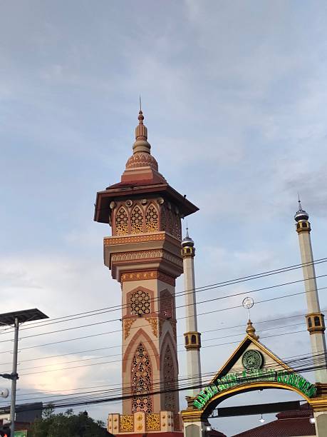 istock A tall mosque minaret with a golden dome under a bright blue sky 2210363863