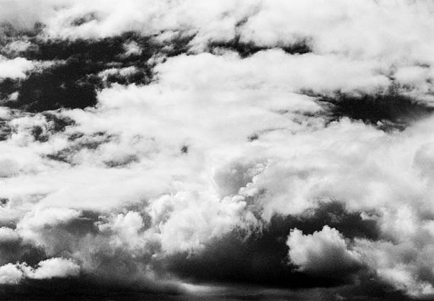 Dramatic skies captured on old-fashioned black and white grainy infrared film (with an analog or analogue SLR film camera and a fast prime wide angle lens with a red filter) in spring.