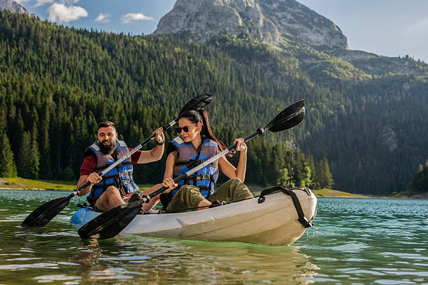 istock Couple kayaking in mountain lake on sunny day 2210364768