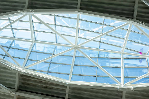 istock Modern steel and glass ceiling structure with sunlight and geometric shadows in contemporary public or industrial building interior, architectural background 2210364814
