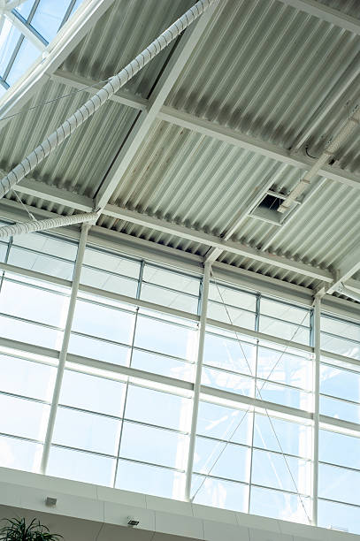 istock Modern steel and glass ceiling structure with sunlight and geometric shadows in contemporary public or industrial building interior, architectural background 2210364824