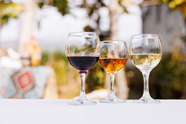 istock Three wine glasses are on a table with different types of wine on Outdoor Table. 2210364893