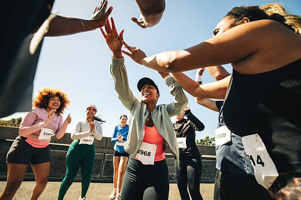 istock Group celebrating success after a running event outdoors 2210365450