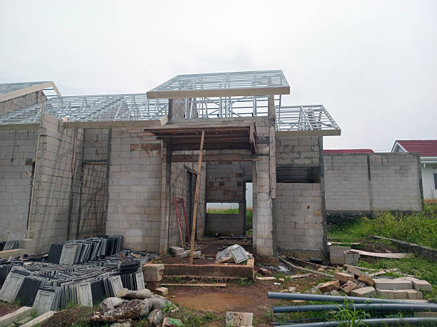 istock Partially Built House with Exposed Roof Frame and Construction Materials 2210365749