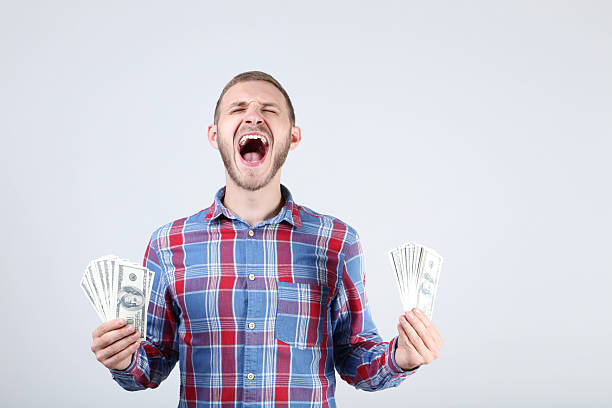 istock Happy young man with dollar banknotes on grey background 2210365861