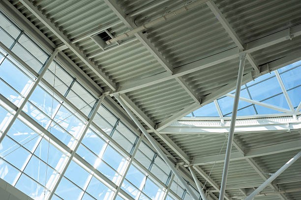 istock Modern steel and glass ceiling structure with sunlight and geometric shadows in contemporary public or industrial building interior, architectural background 2210366197