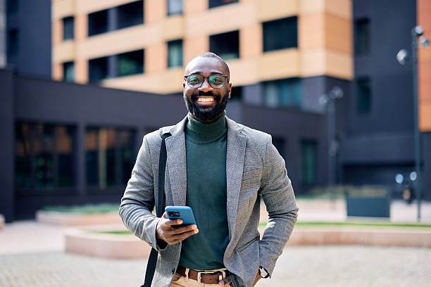 istock Smiling businessman using smartphone in urban setting 2210367035