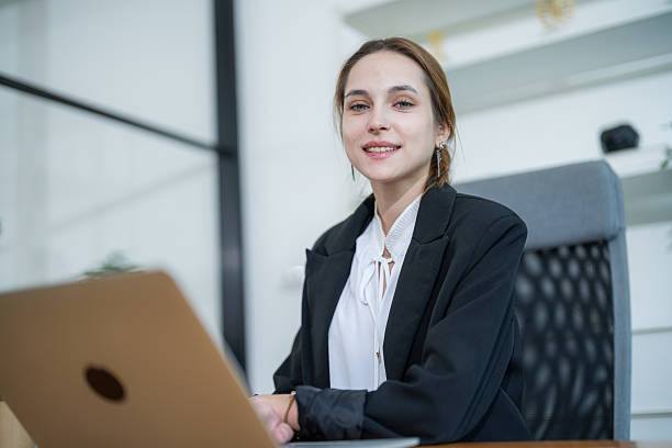 istock Professional young woman working on a laptop in a modern office setting 2210367306