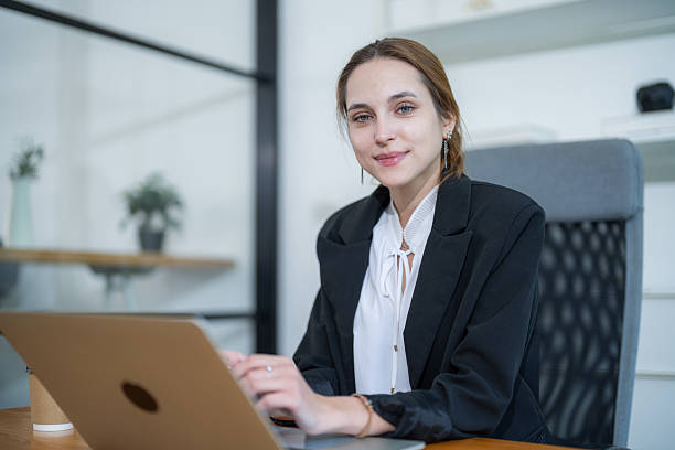 istock Professional woman working on laptop in modern office setting during daytime 2210367324