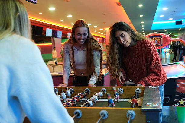 istock Three young women playing table football in an amusement arcade 2210367332