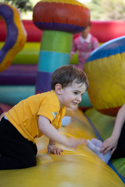 istock Child crawling and playing on inflatable bouncy castle 2210367371