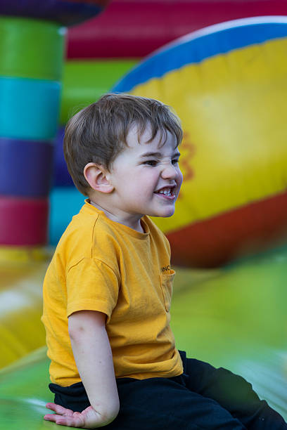 istock Child grimacing and playing on inflatable castle 2210367506