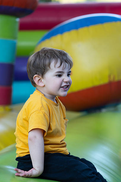 istock Child having fun playing and jumping on inflatable castle 2210367508