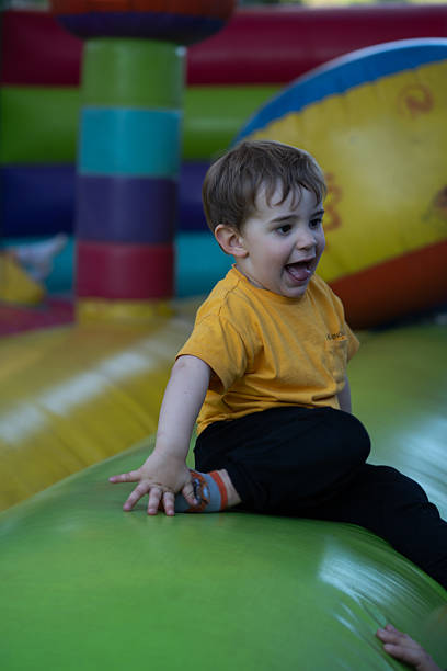istock Excited child playing and jumping on inflatable bouncy castle 2210367512