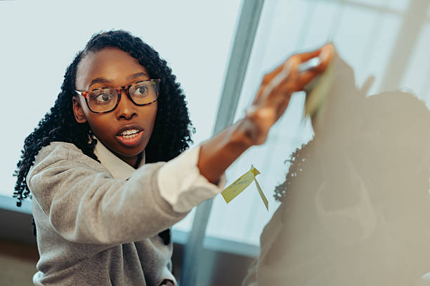 istock African businesswoman using sticky notes on whiteboard 2210367556