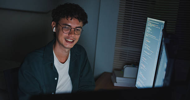 istock Young man software engineer with glasses meeting video conference discussing working late on AI prompt coding on computer in bedroom at home night. Software developer, artificial intelligence. 2210368406