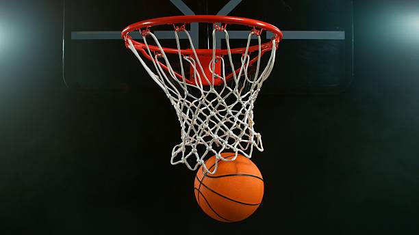 Detail of basketball ball hitting the hoop, top view. Isolated on black background. Freeze motion of sport action.