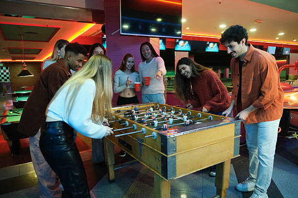istock Young adults playing foosball in an amusement arcade 2210368979
