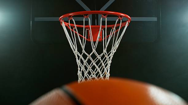 istock Flying Basket Ball into Basket on Black Background 2210369118