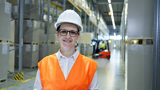 istock Safety-first warehouse worker in an orange vest and hard hat. 2210370332