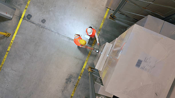 istock Overhead view of workers handling large packages in a warehouse. 2210370507