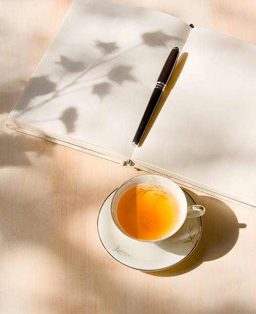 istock Tea in porcelain cup and journal on wooden table 2210371681
