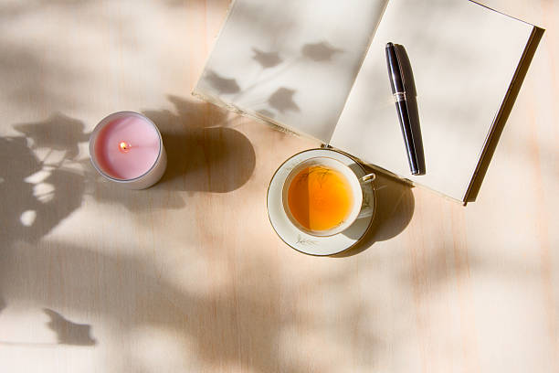 istock Tea in porcelain cup and journal on wooden table 2210371686