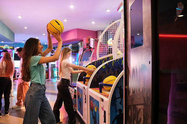 Teenagers having fun playing basketball in a brightly lit arcade