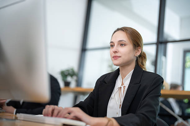 istock Professional woman working on computer in modern office with large windows during daylight hours 2210373255