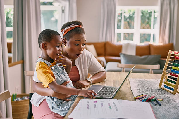 istock Mother, child and laptop for e learning in home with wow, help or education game for development. Black woman, boy and computer for online course, excited or shock for teaching on web at family house 2210374910