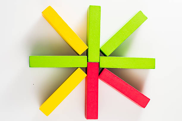 Wooden blocks are arranged on a flat surface in a random order. The multicolored elements look bright and attractive. Wooden play sticks are designed to develop children's motor skills.