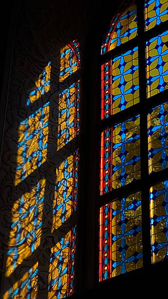 istock Stained glass window with blue and yellow pattern casting shadows 2210378199