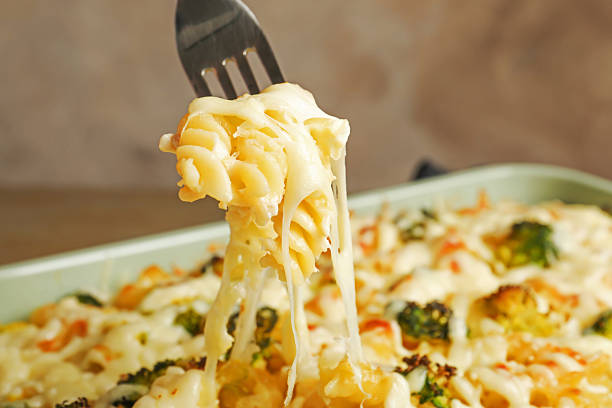Taking tasty pasta casserole with fork from baking dish, closeup