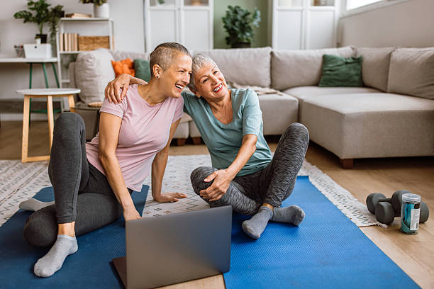 istock Mother and daughter exercising at home together, while watching online video class 2210380901