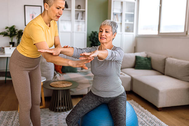 istock Physiotherapist at home visit, doing exercises with senior woman. 2210381142