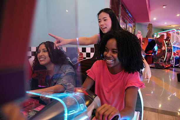 istock Three young women having fun together playing an arcade racing game 2210383732