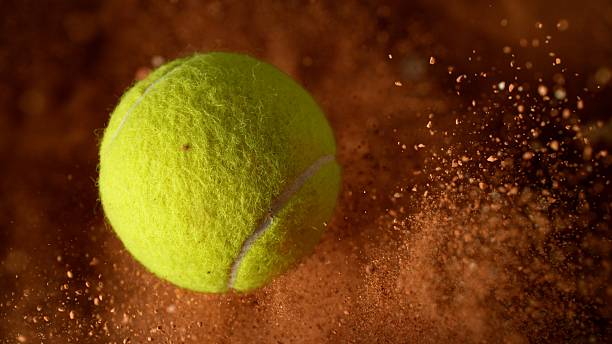 istock Rotating Tennis Ball with Clay Explosion. 2210386578