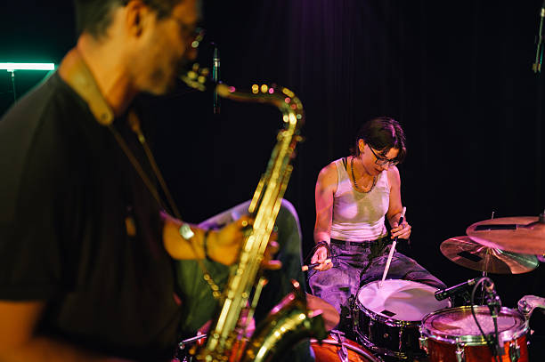 istock Musicians playing saxophone and drums on stage 2210390356